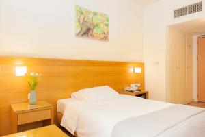 a bedroom with a white bed and a vase of flowers at Athinais Hotel in Athens +32 photos
