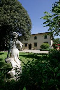 Una statua di una donna che tiene un cesto in un cortile di Fattoria La Gigliola a Montespertoli