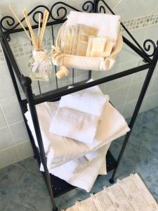 una estantería de cristal con toallas y una cesta. en Villa A'mare, en Savelletri di Fasano