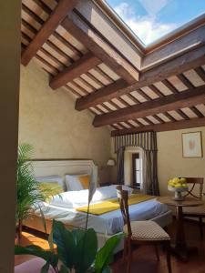 a bedroom with a bed and a ceiling with beams at I giardini segreti di Villa Marcello Marinelli in Cison di Valmarino