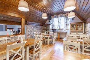 a restaurant with wooden ceilings and tables and chairs at Pension Vasko in Ždiar