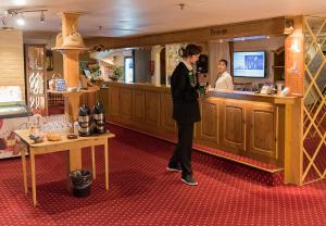 a man standing at a bar in a restaurant at Revsnes Hotel in Byglandsfjord