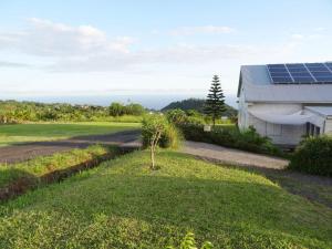 une cour avec une maison dotée de panneaux solaires dans l'établissement le belair, à Carosse