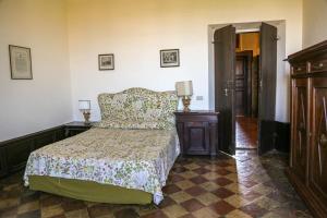 ein Schlafzimmer mit einem Bett und einer Holzkommode in der Unterkunft Villa Malacari in Offagna
