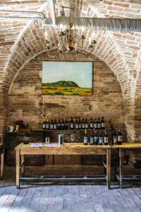 Ein Tisch mit Weinflaschen an einer Backsteinwand in der Unterkunft Villa Malacari in Offagna