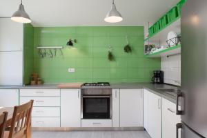 a green kitchen with white cabinets and a stove at Villa Stina in Baška Voda