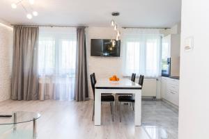 a kitchen and dining room with a white table and chairs at udanypobyt Apartament Silver Centrum in Zakopane
