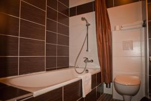 a bathroom with a tub and a toilet at Royal Wagram in Paris