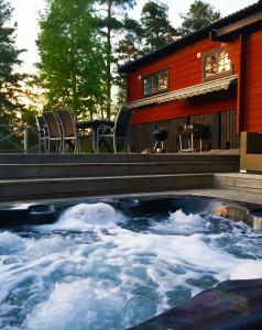 a hot tub in front of a house at Näkna Hill in Åby