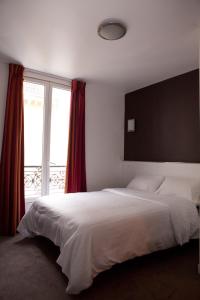 - une chambre avec un grand lit blanc et une fenêtre dans l'établissement Royal Wagram, à Paris