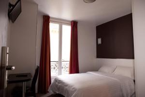 a bedroom with a bed and a window with red curtains at Royal Wagram in Paris