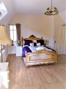 a bedroom with a large bed with a wooden floor at Riverside Bed & Breakfast in Ironbridge