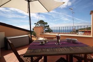 einen Holztisch mit Sonnenschirm auf dem Balkon in der Unterkunft Appartamento Galileo in Poggi