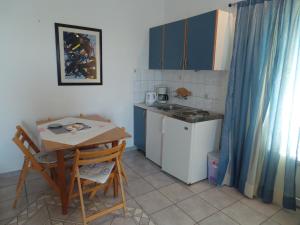 una pequeña cocina con mesa, mesa y sillas en Apartmani Vjera en Ribarica