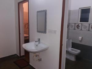 a bathroom with a sink and a toilet at Sherlock Jungle Retreat in Srimangala