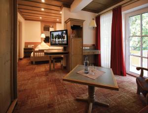 a living room with a television and a table and a couch at Hotel Promenade in Bad Füssing