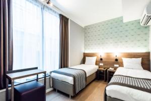 Postel nebo postele na pokoji v ubytování Melrose Hotel