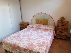 een slaapkamer met een bed en twee nachtkastjes bij VILLA LES NACRES A 400 MT DAL MARE in Porto-Vecchio