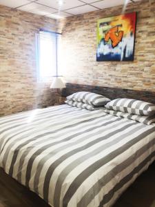 een groot bed in een kamer met een bakstenen muur bij Location! 15m to Beach Mojacar in Mojácar