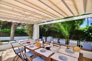 jadalnia ze stołem i krzesłami na patio w obiekcie Villa Bianca w mieście Sitges
