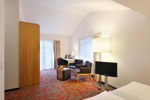 a hotel room with a bed and a living room at Hotel Garni Testa Grigia in Zermatt