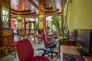 a room with chairs and tables and a television at Side Walk Hotel in Siem Reap