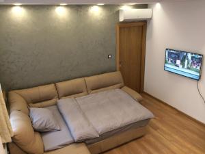 a couch in a living room with a flat screen tv at Light in the heart in Sofia