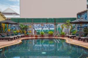 a swimming pool in front of a wall with graffiti at Side Walk Hotel in Siem Reap
