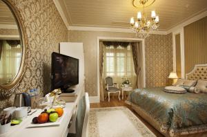 Un dormitorio con una cama y una mesa con frutas. en Limak Thermal Boutique Hotel, en Gokcedere