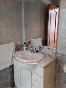 uma casa de banho com um lavatório e um espelho em Hostal San Andres em Carboneras