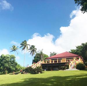 a building with palm trees in front of a field at Porta Verde Resort Villas Caliraya in Cavinti