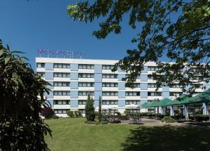 a large white building with a park in front of it at Mercure Hotel Mannheim am Friedensplatz in Mannheim