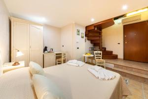 a bedroom with a white bed and a staircase at B&B La Casa Nel Giardino in Piano di Sorrento