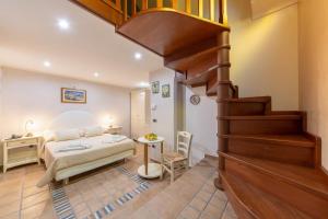 a bedroom with a bed and a spiral staircase at B&B La Casa Nel Giardino in Piano di Sorrento