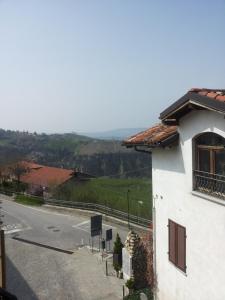 a white building with a view of a road at Conte Caramelli Apartment in Montelupo Albese