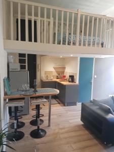 Una sala de estar con una mesa y una cocina. en Studio Du Marche, en Dinan