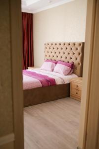 リヴィウにあるBilya Taurusuのベッドルーム1室(ピンクの枕が付いた大型ベッド1台付)
