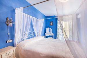 a bedroom with a white canopy bed and blue walls at Stylish Apartment in Villajoyosa