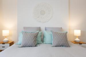 um quarto com uma cama com almofadas azuis e brancas em Stylish and Spacious, Downtown Mount Maunganui em Mount Maunganui