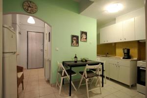 アテネにあるLuxury flat in Kolonaki, 3’ Metroのキッチン(テーブル、椅子、壁掛け時計付)