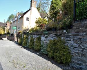 a stone retaining wall next to a house at Riverside Bed & Breakfast in Ironbridge