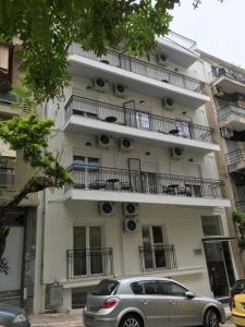 un edificio con balconi e una macchina parcheggiata di fronte di Olympus Residence ad Atene