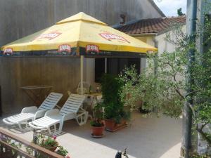 - une terrasse avec 2 chaises et un parasol dans l'établissement Apartment Artusi, à Pula