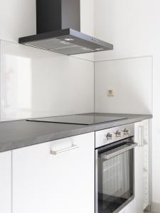 a kitchen with white cabinets and a stove top oven at City Park Apartments - #1-8 - Stilvolle Apartments zentrumsnah in Leipzig