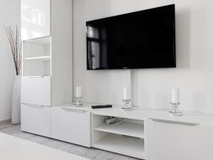 ein weißes Wohnzimmer mit einem TV an der Wand in der Unterkunft City Park Apartments - #1-8 - Stilvolle Apartments zentrumsnah in Leipzig