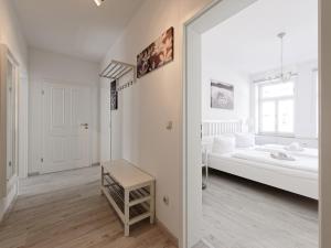 ein weißes Zimmer mit einem Bett und einem Tisch in der Unterkunft City Park Apartments - #1-8 - Stilvolle Apartments zentrumsnah in Leipzig