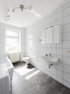 ein weißes Bad mit einem Waschbecken und einem WC in der Unterkunft City Park Apartments - #1-8 - Stilvolle Apartments zentrumsnah in Leipzig