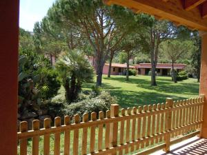una valla de madera frente a un patio con árboles en Casa Campanella Resort, en Capoliveri