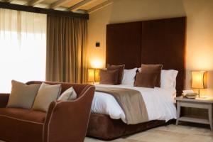 グレッツァーナにあるCa' del Moro Wine Retreatの大きなベッドと椅子が備わるホテルルームです。