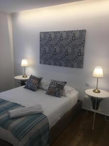 a bedroom with a bed with two tables and two lamps at Casa do Peso 2 in Peso da Régua